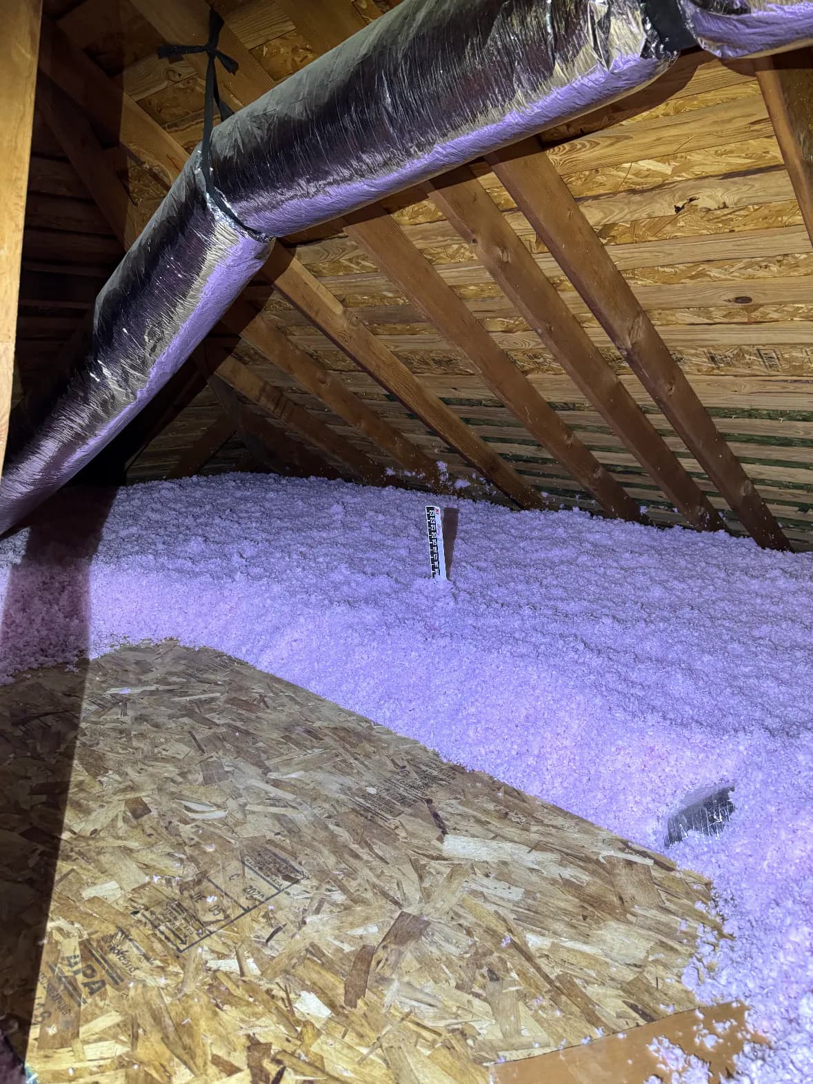 Blown-in fiberglass insulation installed across a residential attic floor