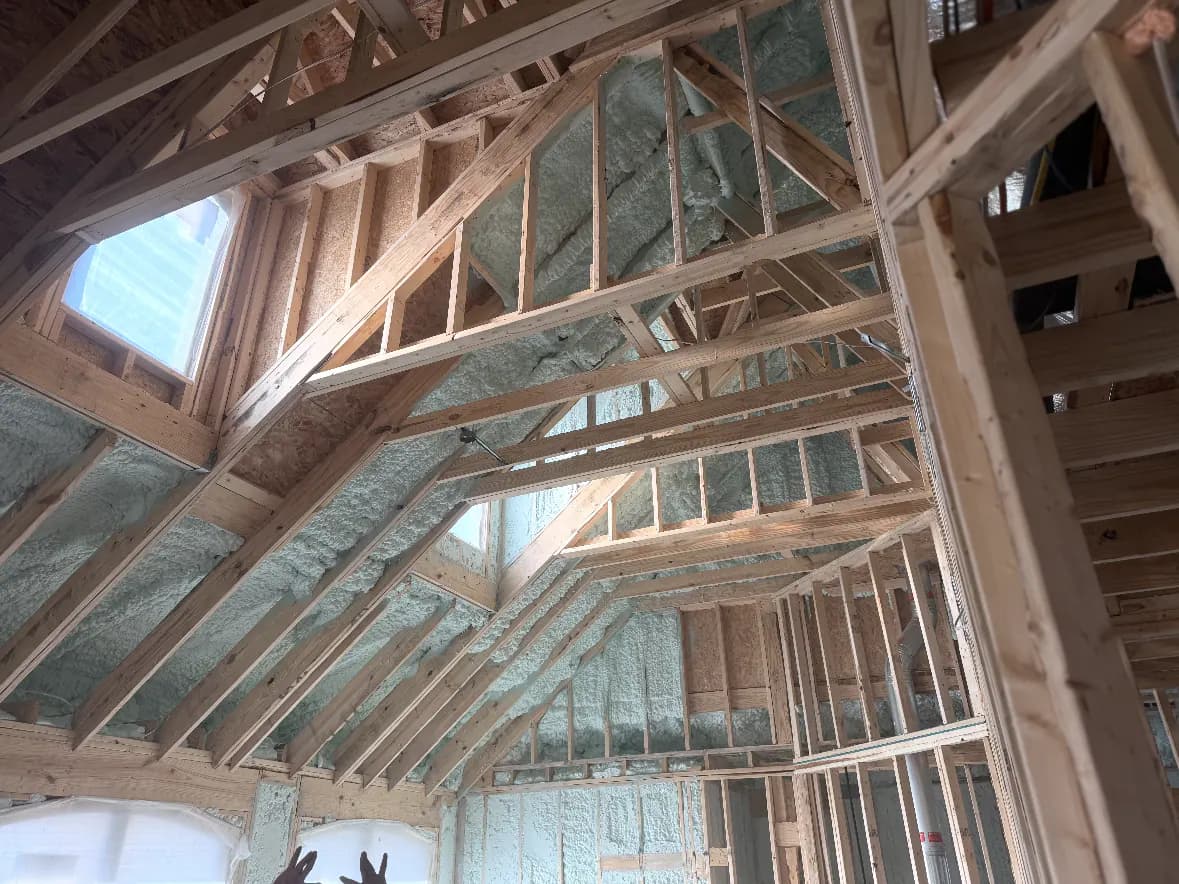 New residential framing with spray foam installed at wall and roofline cavities