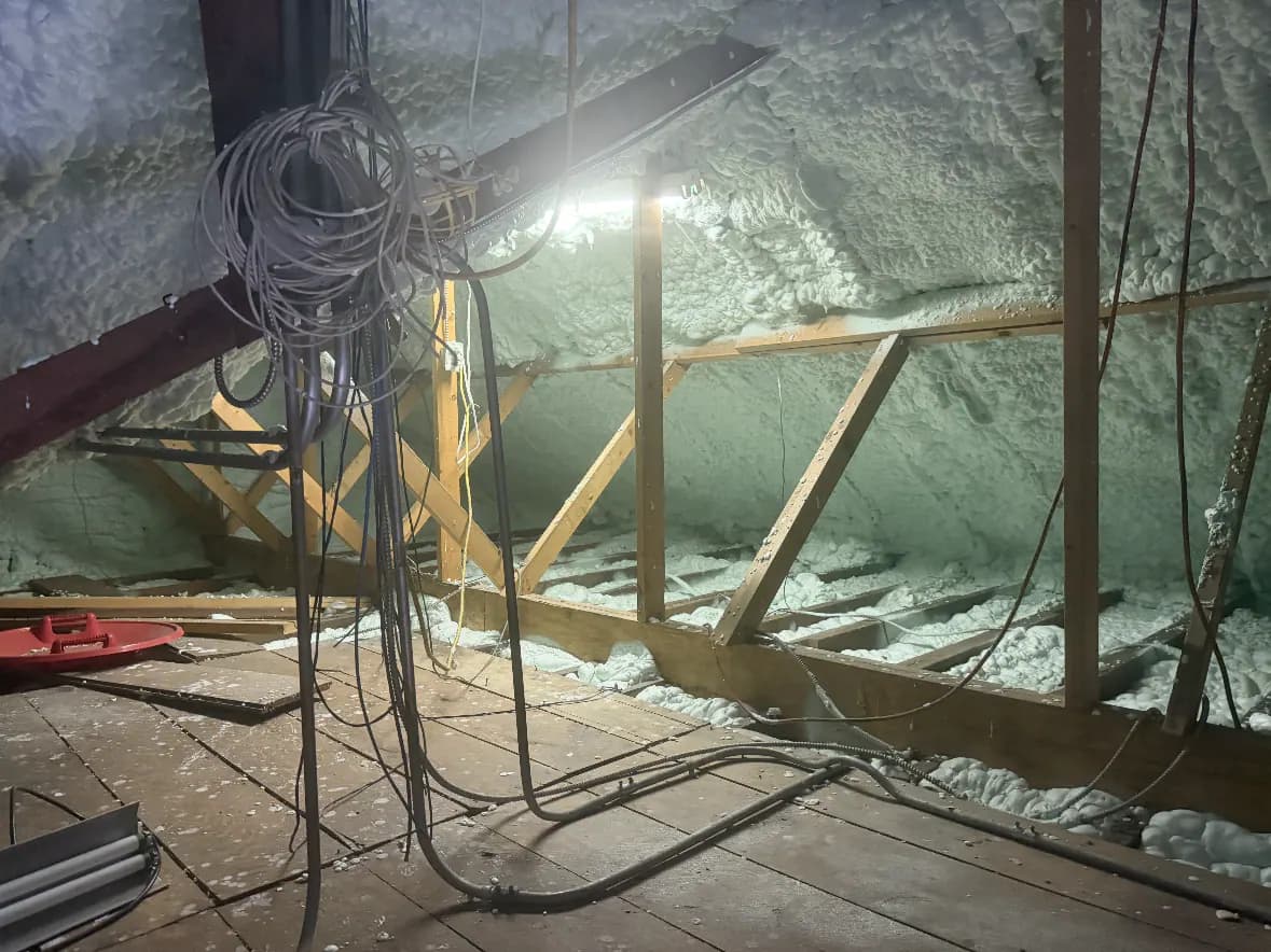 Spray foam attic worksite with equipment and protected access area